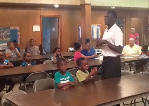 Rev. Kariuki speaks to the students at vacation Bible school.